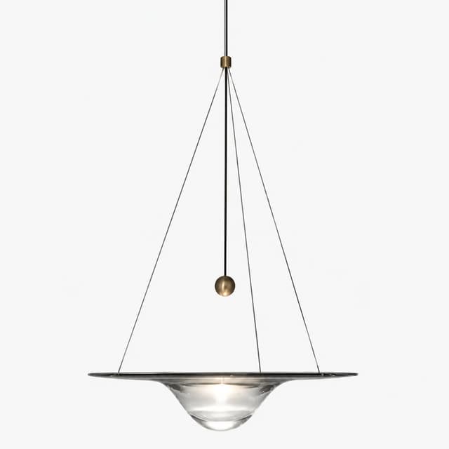 Front view of clear glass saucer pendant light with central illuminated lens, brass accent and fine suspension wires