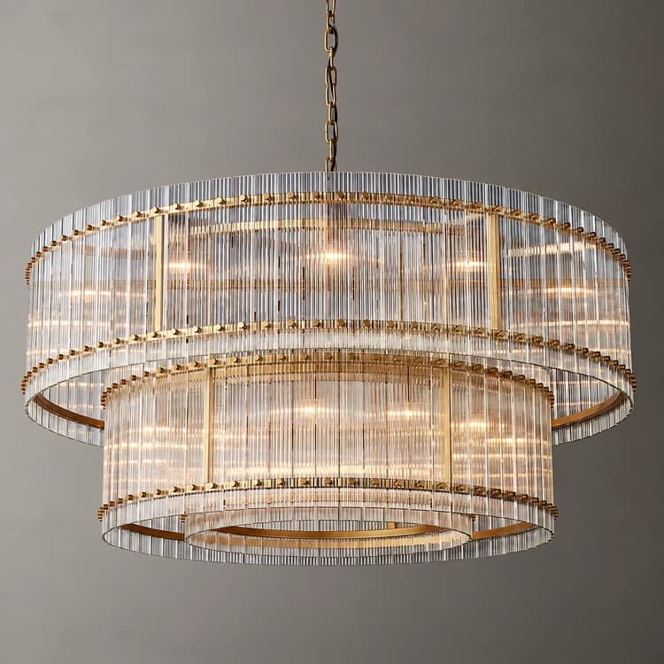 A large, two tier, transparent, crystal style circular chandelier featuring electroplated copper colored metal rings and warm lighting