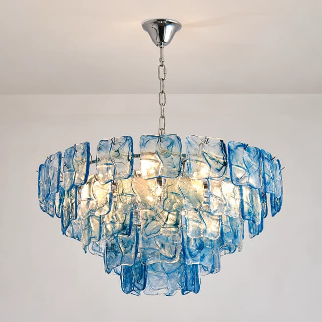Illuminated blue glass chandelier with layered panels and a reflective metal frame