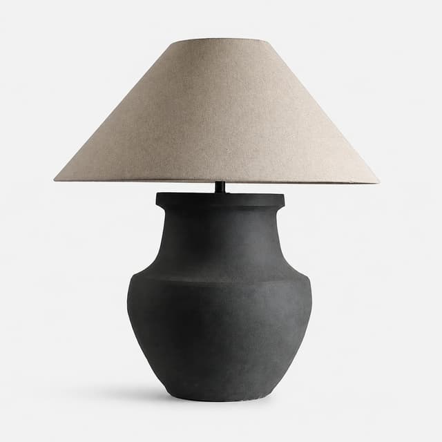 Matte black ceramic urn table lamp with wide natural beige fabric shade on white background