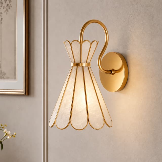 Close up of a gold shell wall sconce with luminous textured natural shell panels and sculptural metal framing