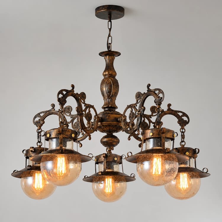 Front view of a vintage bronze five light chandelier with ornate scrollwork and translucent seeded glass globes
