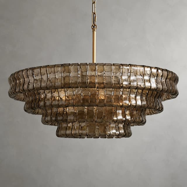 Detailed view of textured glass chandelier layers with warm illumination and reflective glass surfaces