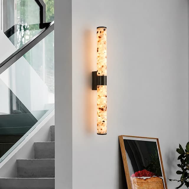 Long terrazzo and blackened brass LED wall sconce beside a modern staircase