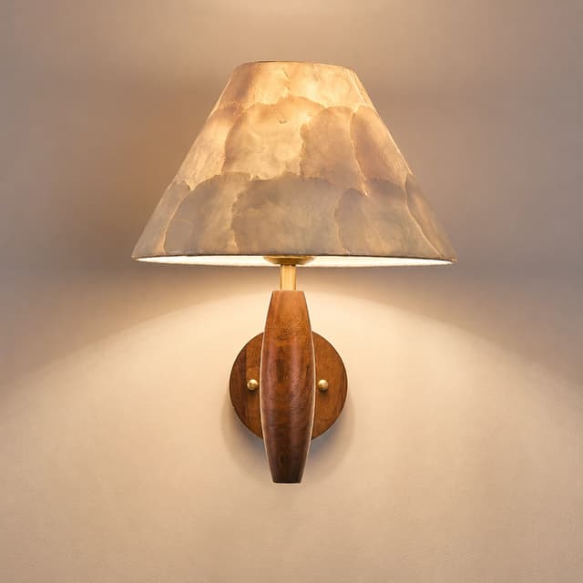 Close up of tapered natural Capiz shell shade on a warm wood wall sconce