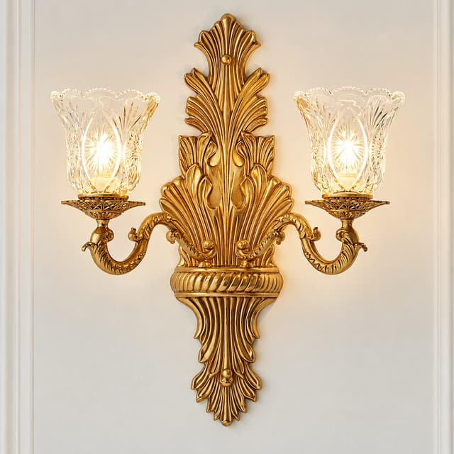 Traditional antique gold two light wall sconce with sculptural leaf backplate and decorative glass shades