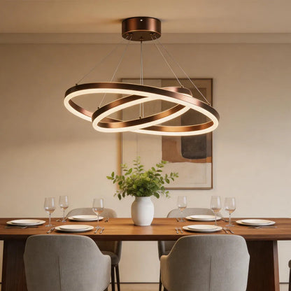 Blackened copper double ring LED chandelier above wooden dining table