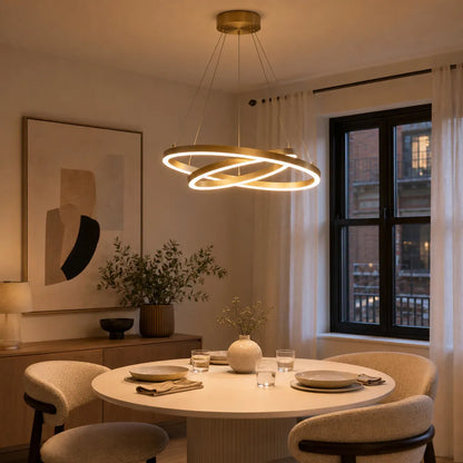 Modern double ring LED chandelier in copper with acrylic diffuser above dining table