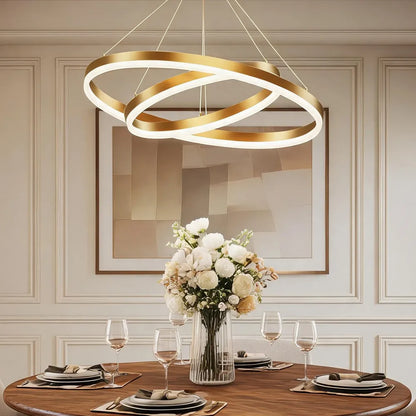Modern double ring LED chandelier in copper with acrylic diffuser above dining table