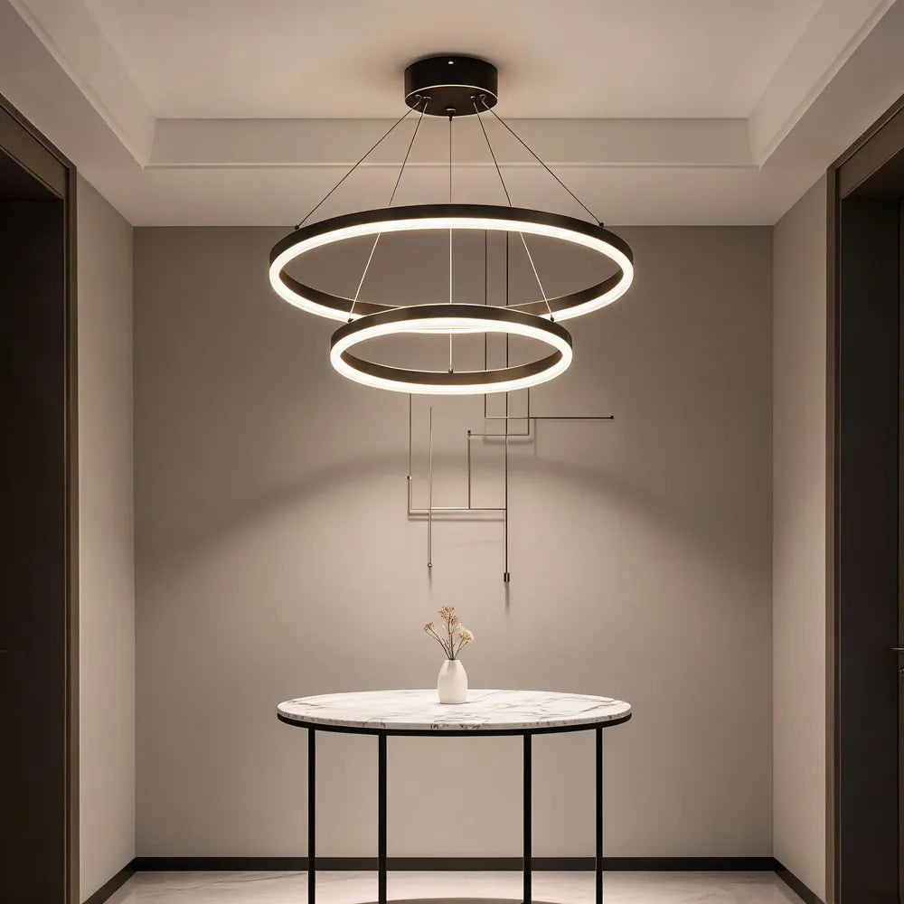 Double ring LED chandelier above marble console table in modern foyer
