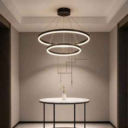 Double ring LED chandelier above marble console table in modern foyer