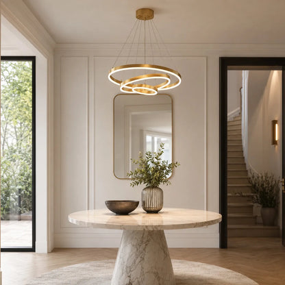 Gold LED ring chandelier hanging in a bright entryway with adjustable cable suspension