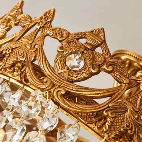 Close up of faceted clear crystal strands with gold tone connecting links on a luxury chandelier