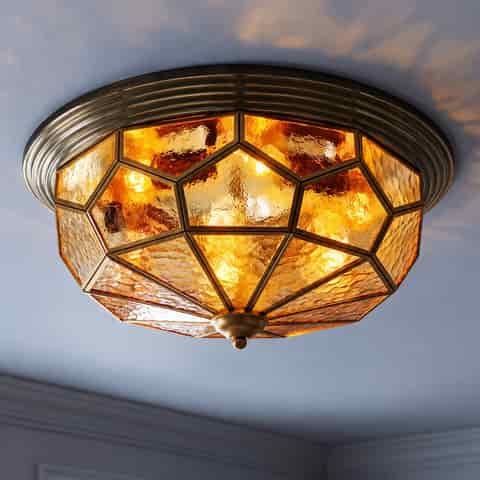 Tiffany style amber stained glass semi flush ceiling light glowing warmly in a classic interior