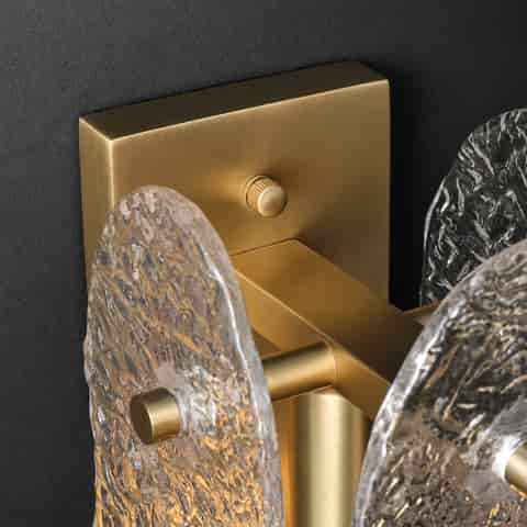 Close up of brass finish textured glass wall sconce with layered organic glass panels
