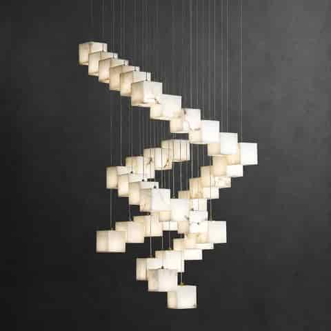 Large marble cube staircase chandelier creating a sculptural cascade in a double height foyer