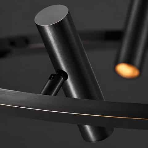 Close up of black metal ring chandelier with brushed cylindrical adjustable spotlight head and slim warm metallic edge detail