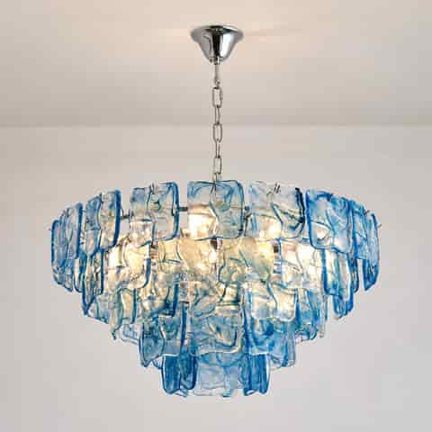Illuminated blue glass chandelier with layered panels and a reflective metal frame