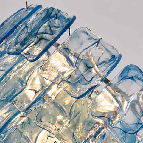 A close up detail of a transparent blue chandelier featuring Murano glass elements, showcasing flowing textures