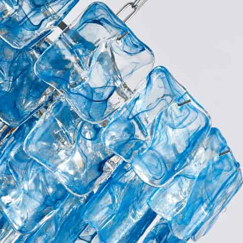 Close up of transparent blue glass chandelier panels with flowing artistic patterns