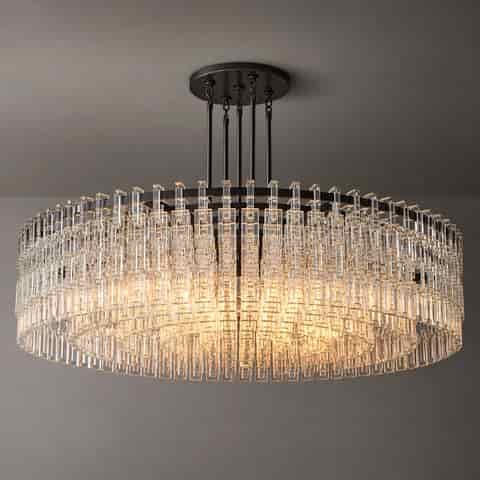 Close up of a black metal drum chandelier with layered clear rectangular decorative accents and warm lighting