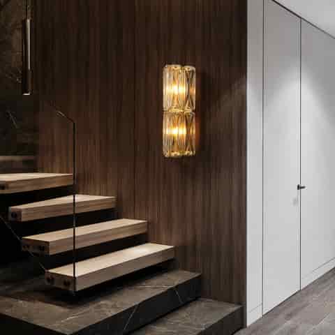 Double tier clear glass block wall sconce installed beside a modern staircase