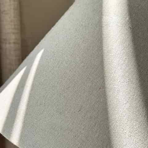 Close up of natural beige woven fabric shade for black ceramic table lamp