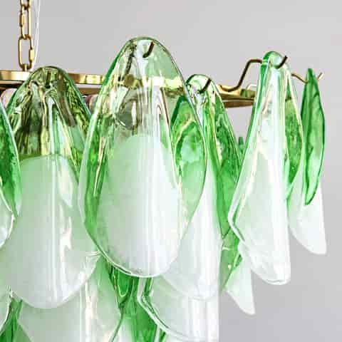 Close up of green and clear Murano glass petal shades on a gold tone metal chandelier