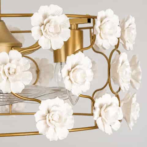 Close up of white ceramic flower accents on gold floral fandelier ceiling fan