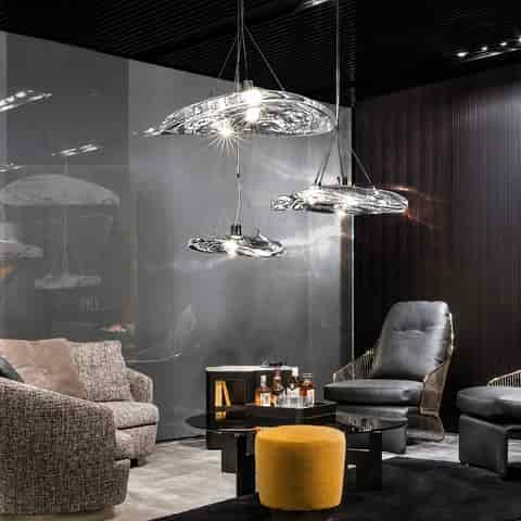 Sculptural clear glass pendant chandelier installed in a contemporary living room with luminous organic glass forms