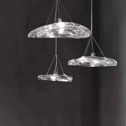 Three sculptural clear glass pendant lights in different sizes with organic irregular forms and slim cable suspension