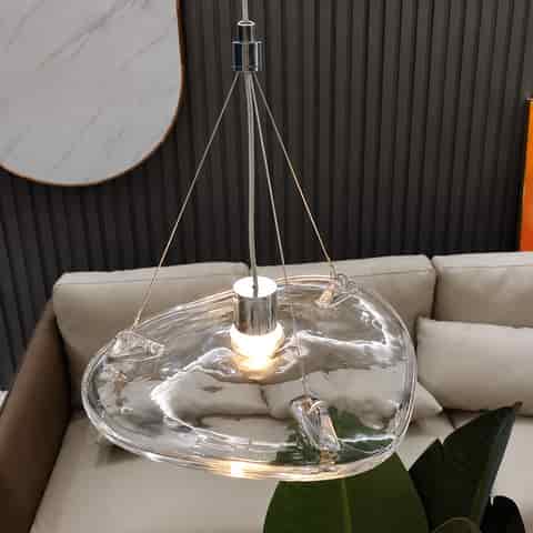 Organic clear glass pendant chandelier with a fluid rippled shade, polished metal fittings and warm illuminated center