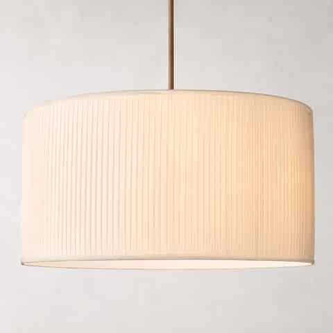 Ivory pleated fabric drum pendant light with warm ambient glow and slim metal suspension rod