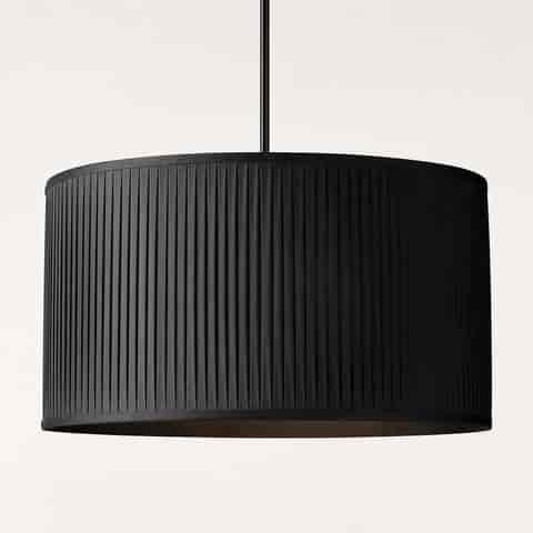 Close up of black pleated fabric drum pendant shade with vertical textured folds