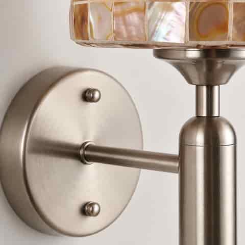 Close up of the brushed nickel wall plate, mounting arm, and cylindrical metal fixture details