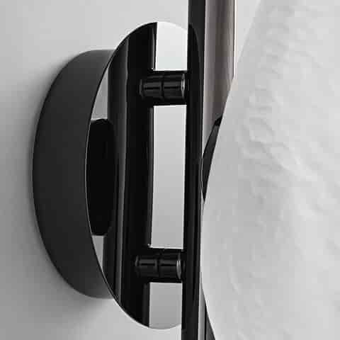 Close up of glossy black metal backplate and mounting structure on modern glass wall sconce