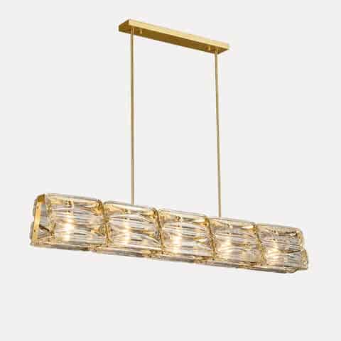 Gold copper and clear textured glass linear chandelier glowing warmly against a dark background 125cm