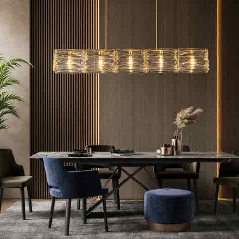 Gold copper and textured glass linear chandelier installed above a modern rectangular dining table