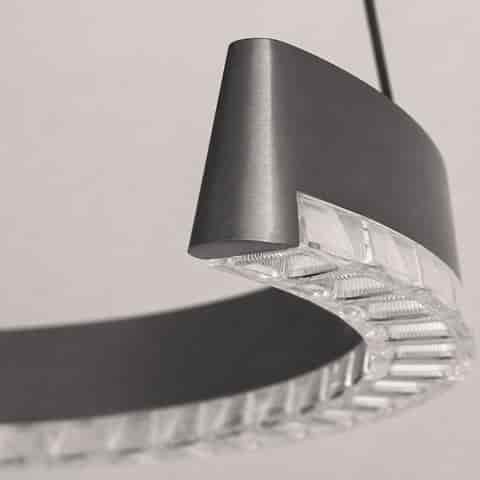 Close up of brushed graphite gray metal chandelier showing the clear faceted diffuser and softly curved ring profile