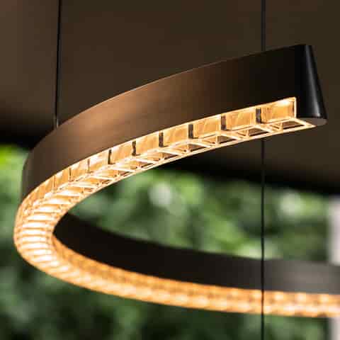 Brushed graphite gray spiral LED chandelier with clear faceted diffuser and warm illuminated open ring detail