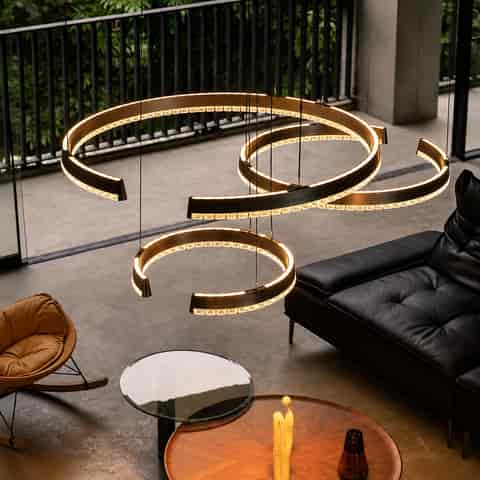 Sculptural graphite gray spiral LED pendant lights installed in a contemporary living room with layered circular forms