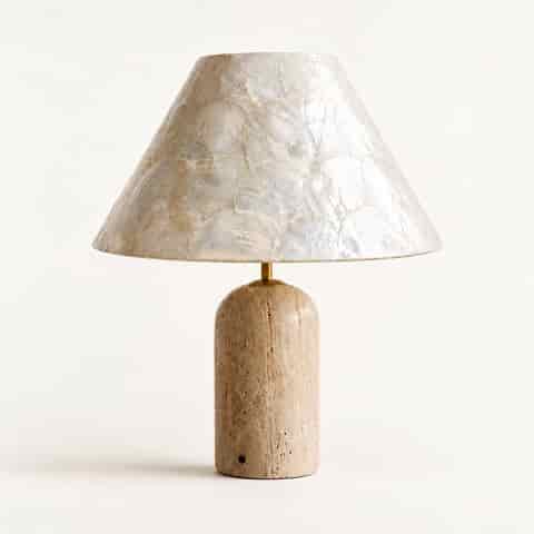 Seashell table lamp on a clean white background featuring layered ivory shells and a warm beige textured base
