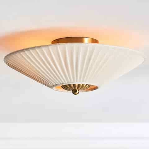 Copper finish Art Deco flush mount ceiling light with a softly glowing ivory pleated fabric shade
