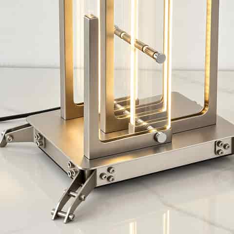 Detailed view of the metal base, glass panels, LED light elements and precision hardware on a sculptural floor lamp