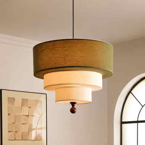 Olive green and cream three tier drum pendant light above a mid century wood cabinet
