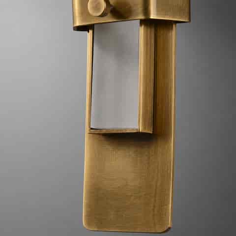 Close up of brushed brass wall sconce backplate and internal light structure