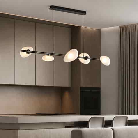 Modern six light linear chandelier with frosted organic glass shades above a minimalist kitchen island