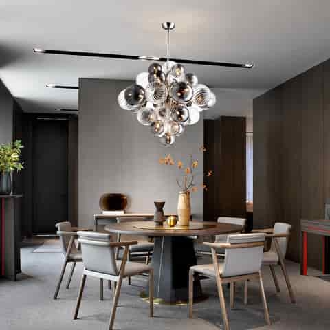 Modern bubble glass chandelier with smoked and clear globes displayed in a contemporary round dining room