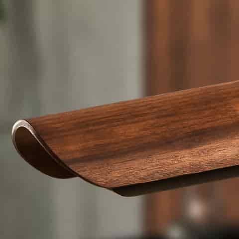 Close up of curved wood grain finish on a linear pendant light