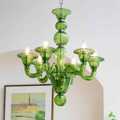 Green colored glass chandelier with multi arm silhouette and warm glowing bulbs